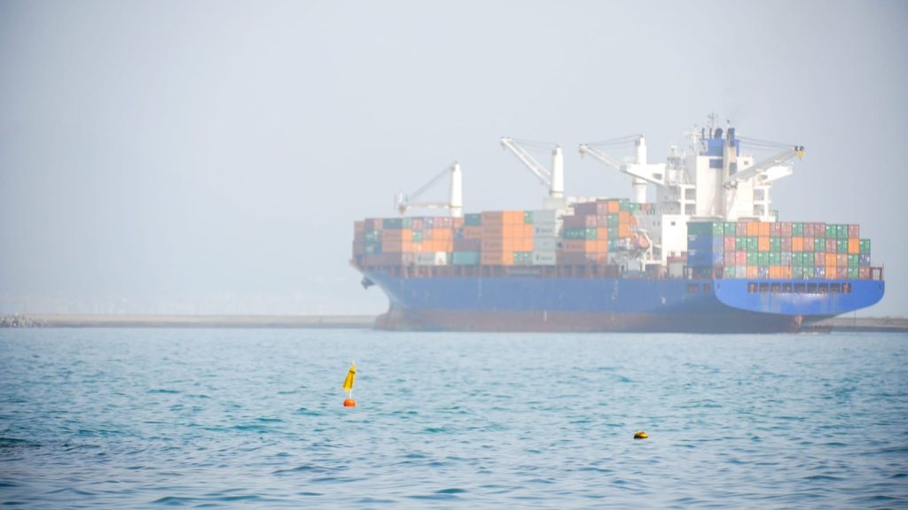 101143334-cargo-ship-navigating-in-hazy-port-waters